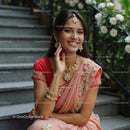Elegant Woman in Pink Saree with Jewelry on Staircase