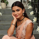Elegant Woman in Pink Saree with Jewelry on Staircase