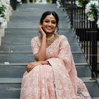 Elegant Woman in Pink Saree with Jewelry on Staircase