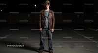 Young Man in Leather Jacket Standing in Dimly Lit Parking Lot
