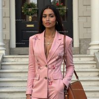 Elegant Woman in Floral Pink Suit Standing Outside
