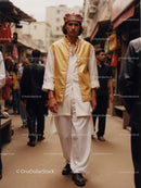 Man in Traditional Attire Walking Through Bustling Market Street