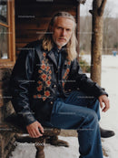 Man in Embroidered Leather Jacket at Rustic Cabin