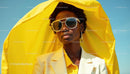 Stylish Woman in Yellow Attire Under Sunlit Sky