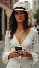 Elegant Woman in White Dress with Smartphone in City