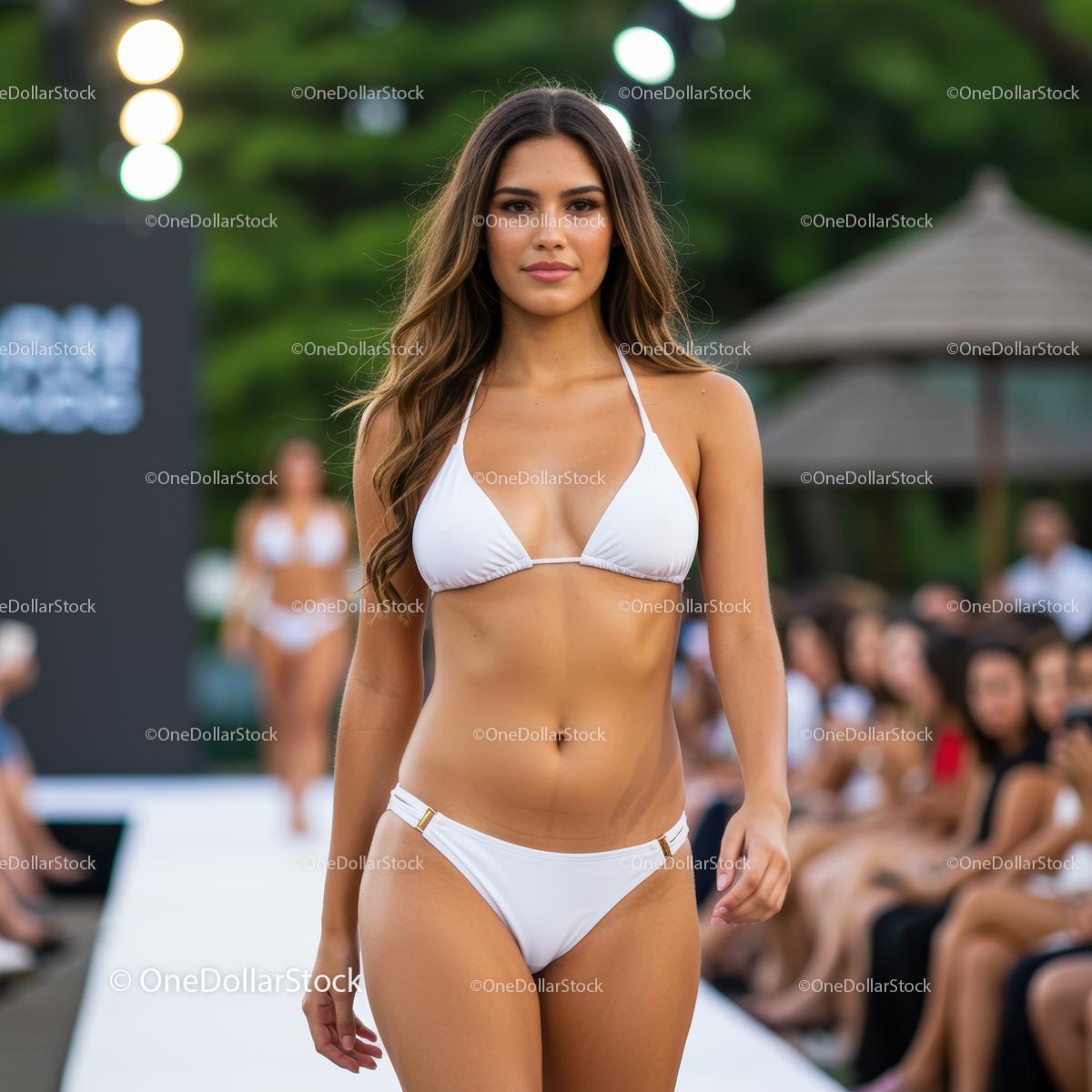 Pewna siebie modelka w białym bikini na pokazie mody na świeżym powietrzu