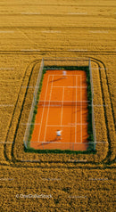 Solitary Tennis Player on Green Court with Lush Surroundings