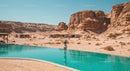 Luxurious Desert Resort with Turquoise Pool and Rocky Cliffs