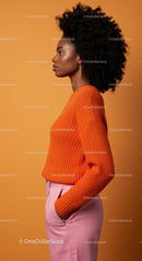 Stylish Woman in Orange Sweater with Afro Hair on Orange Background