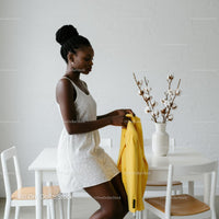 Stylish Woman Holding Yellow Blazer in Minimalist Interior