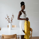Stylish Woman in White Dress Holding Yellow Jacket