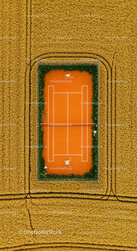 Solitary Tennis Player on Green Court with Lush Surroundings
