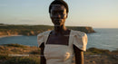 Elegant Woman Posing at Sunset by the Ocean