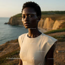 Elegant Woman in Beige Dress on Coastal Cliff at Sunset