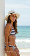 Smiling Woman in Striped Bikini Enjoying a Sunny Beach Day