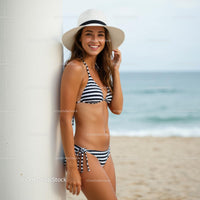 Smiling Woman in Striped Bikini and Sun Hat on a Sandy Beach