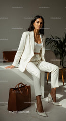 Stylish Woman in White Suit with Brown Handbag in Modern Office