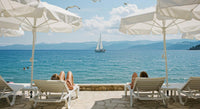 Serene Beachfront Relaxation with Sailboat on Horizon