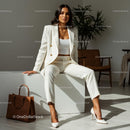 Stylish Woman in White Suit with Brown Handbag in Modern Office