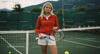 Young Woman in Red Sweater on Tennis Court with Racket