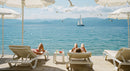 Sunbathing by the Seaside with Sailing Boat in View