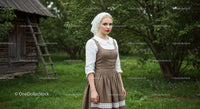 Woman in Traditional Dress in Lush Countryside Setting