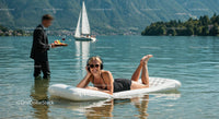 Woman Relaxing on Inflatable Mattress in Mountain Lake