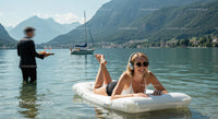 Woman Relaxing on Inflatable Raft in Scenic Mountain Lake