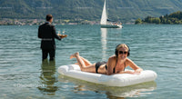 Woman Relaxing on Inflatable Mattress in Mountain Lake
