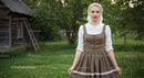 Woman in Traditional Attire by Rustic Cottage