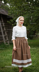Woman in Traditional Dress Stands in Lush Countryside
