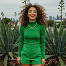 Smiling Woman in Green Clothes with Curly Hair