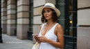 Stylish Woman in White Dress Using Smartphone on City Street