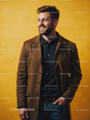Smiling Man in a Brown Coat Against Yellow Background