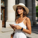 Woman in White Dress and Straw Hat Using Smartphone