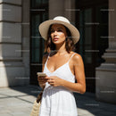 Woman in White Summer Dress and Sun Hat on City Street