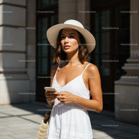 Woman in White Summer Dress and Sun Hat on City Street
