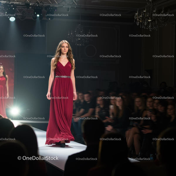 Elegant Model in Red Evening Gown on Fashion Show Runway