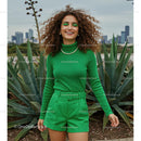 Smiling Woman in Vibrant Green Outfit with Curly Hair