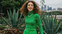 Smiling Woman in Green Outfit Amidst Agave Plants
