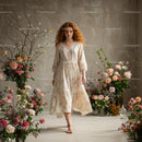 Woman in Vintage Dress Amidst Lush Floral Arrangements