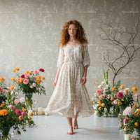 Woman in Flowing Dress Surrounded by Vibrant Flowers