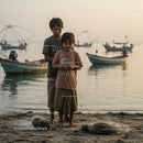 Children Preparing Fishing Nets on a Tranquil Beach