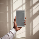 Hand Holding Tablet Against Soft Window Light