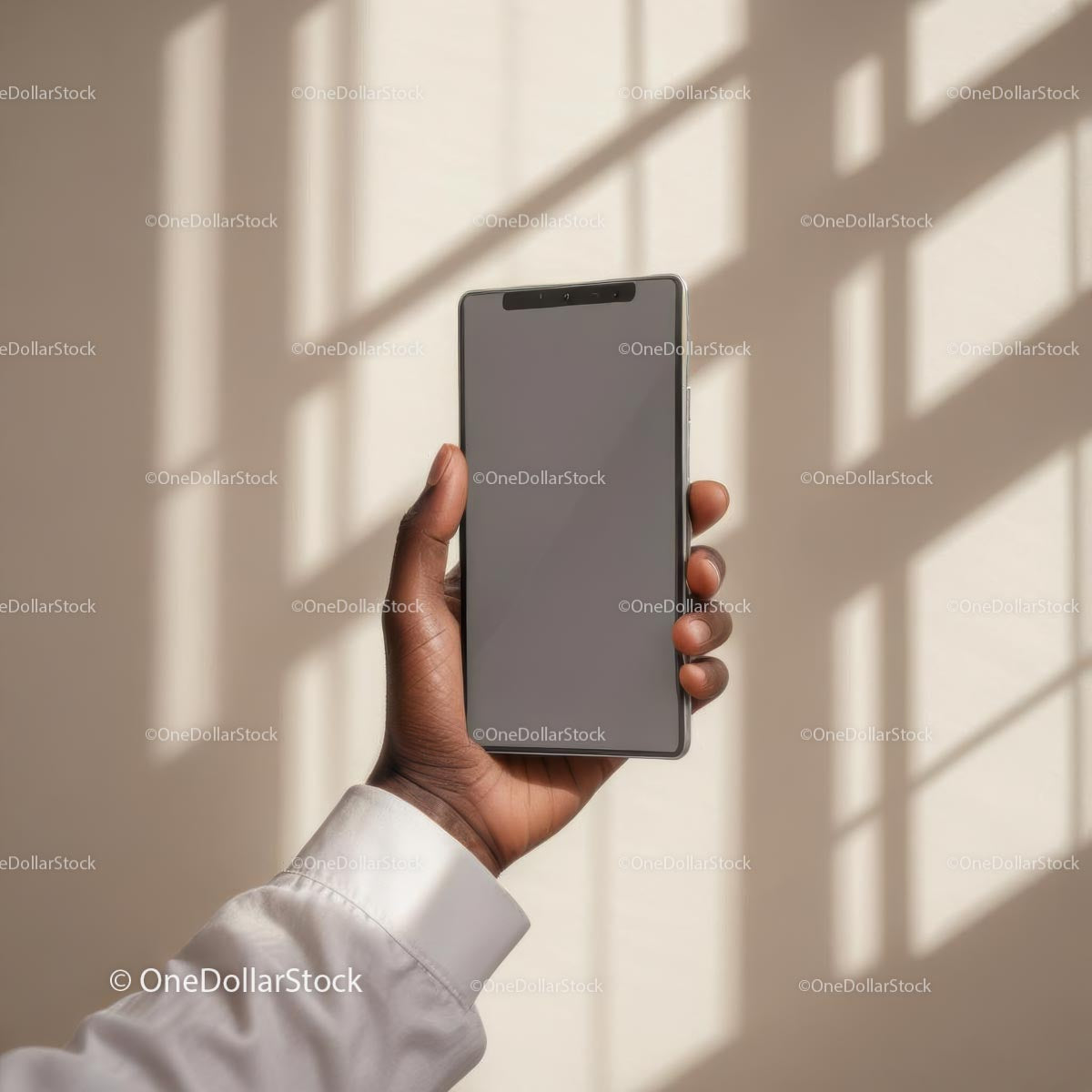Dłoń trzymająca nowoczesny smartfon na tle rozświetlonego słońcem