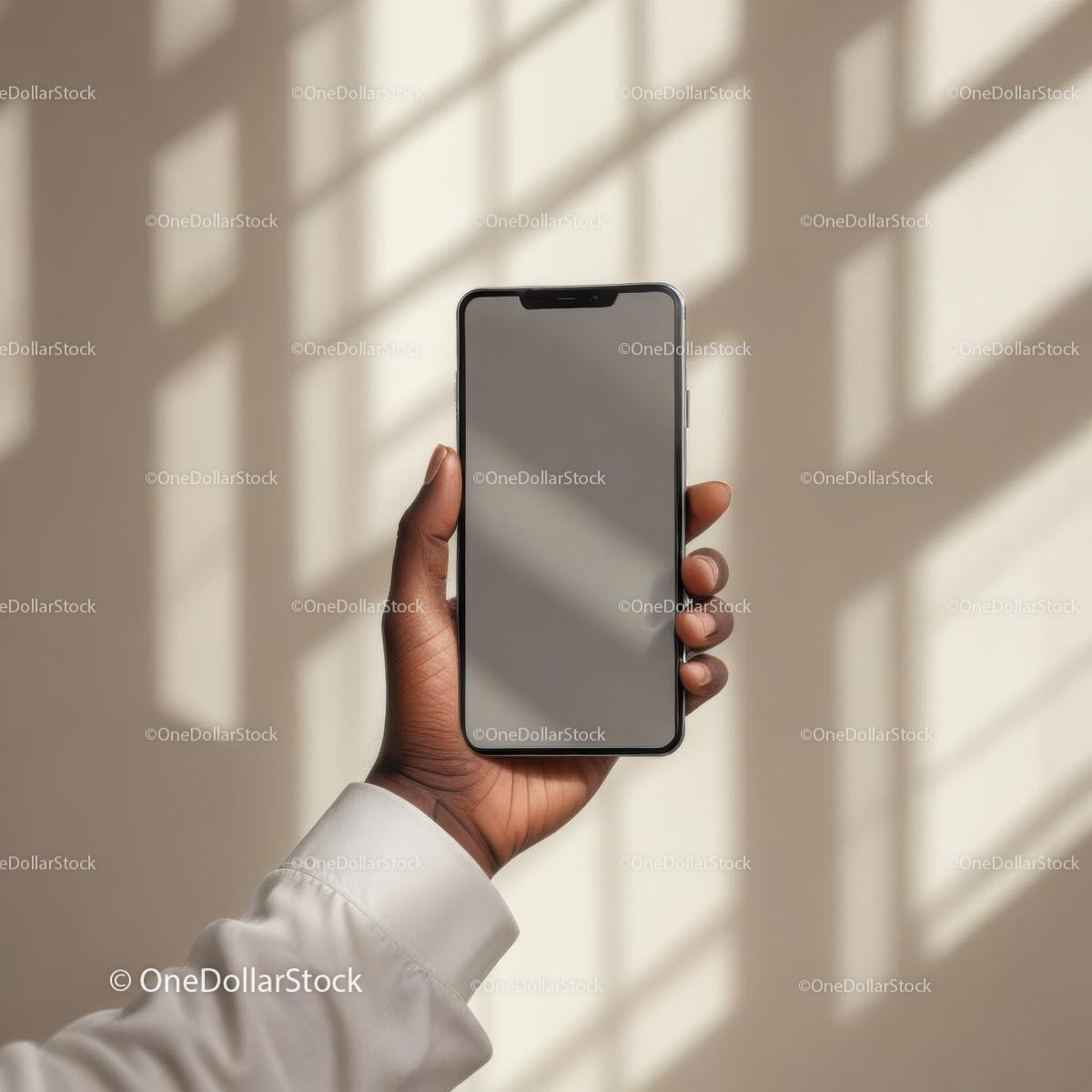 Hand Holding Smartphone Against Beige Shadowed Wall