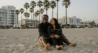 Smiling Couple Relaxing on a Sandy Beach with Palm Trees