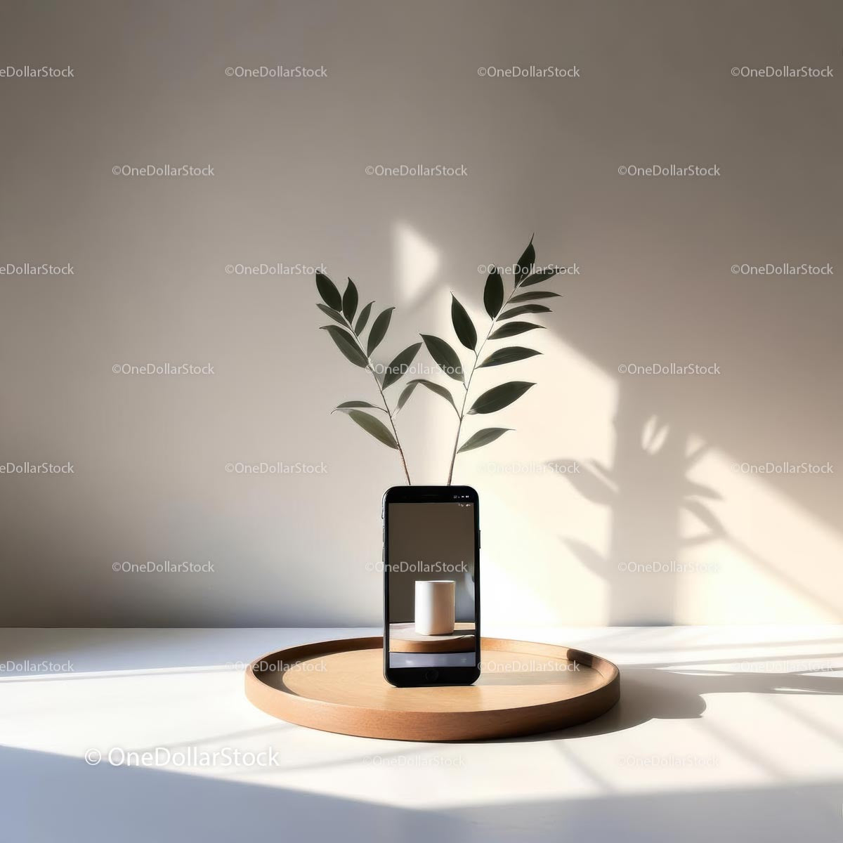 Smartfon i zielone liście w minimalistycznym otoczeniu