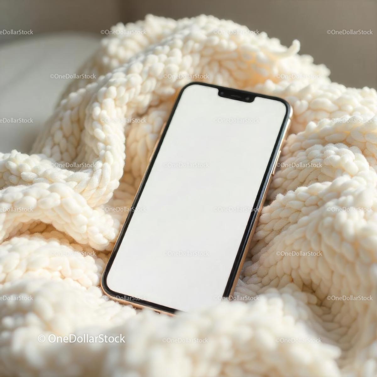 Smartfon na przytulnym dzianinowym kocu w delikatnym świetle