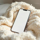 Smartphone on Cozy Knitted Blanket in Soft Light